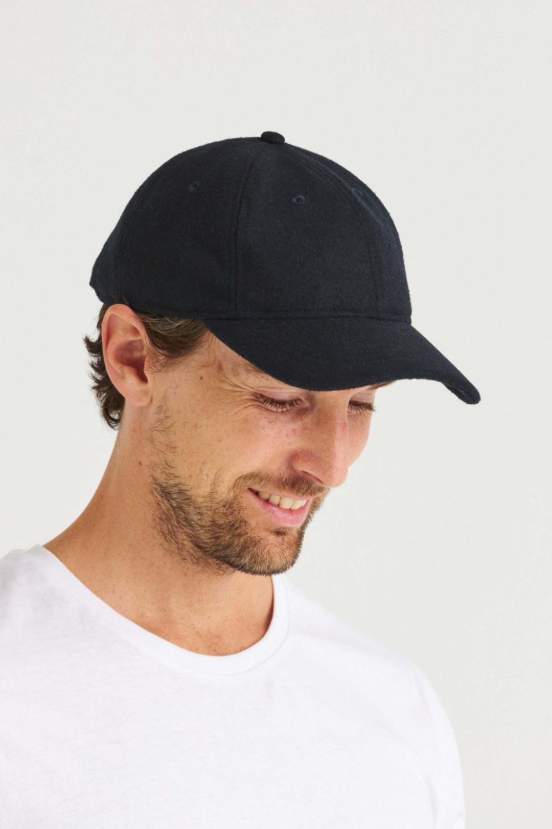 Marinblå Keps Wool Look, en stilren keps i mjuk kvalitet, person som bär den.