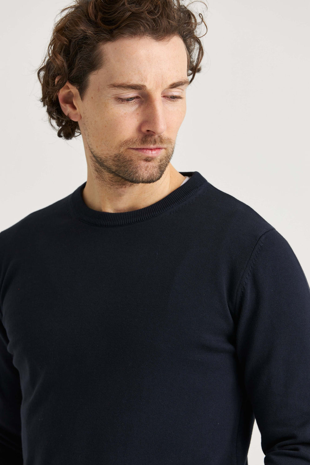 Marinblå finstickad bomullströja på man som visar stil och elegans.