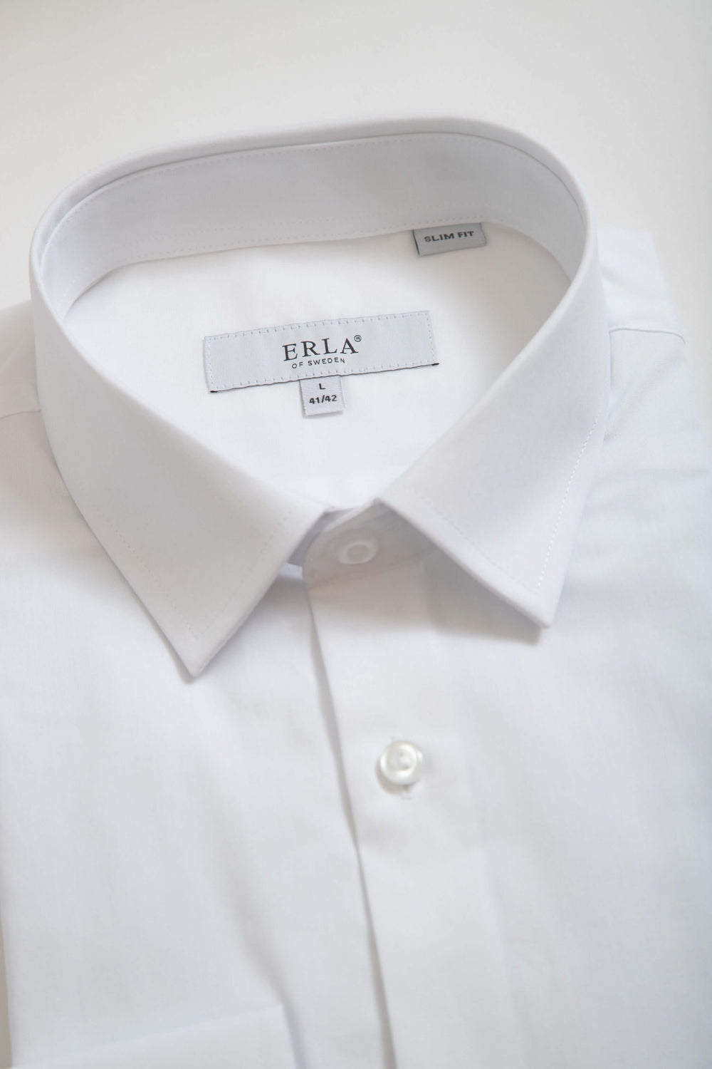 Vit slim fit-skjorta med klassisk design och elegant silhuett, perfekt för högtidliga tillfällen.