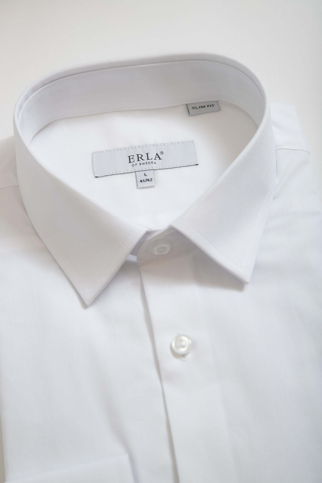 Vit slim fit-skjorta med klassisk design och elegant silhuett, perfekt för högtidliga tillfällen.